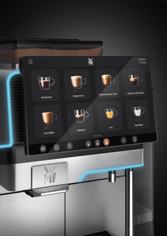Na zdjęciu przedstawiono duży ekran dotykowy ekspresu WMF Elevation 10, prezentujący intuicyjne menu napojów. Widoczne są ikony kawowych klasyków, takich jak Americano, Cappuccino, Flat White, Ristretto, Espresso Macchiato, a także opcje herbaty, gorącej wody i napojów mlecznych (np. Chilled Almond Latte). Przejrzysty interfejs umożliwia łatwą nawigację i personalizację napojów, zarówno w trybie samoobsługowym, jak i serwisowy